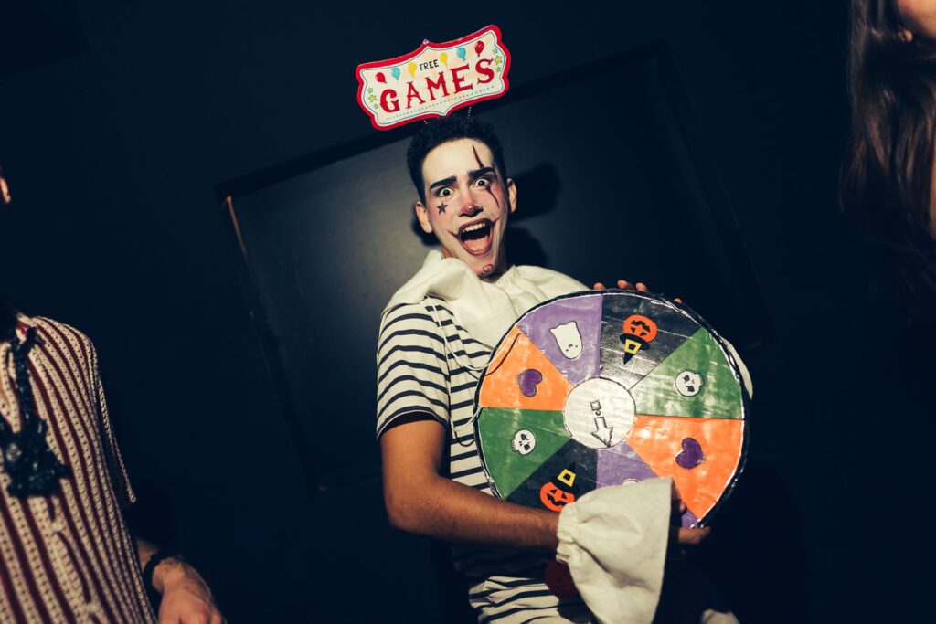Chico maquillado de payaso con una ruleta de juegos de Halloween en una fiesta en Florencia
