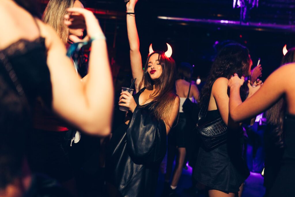 Girl with devil horns dancing at a Halloween party in Florence