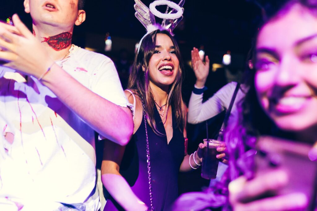 Crowded dance floor with fake wound make-up and an angel halo on Halloween in Florence