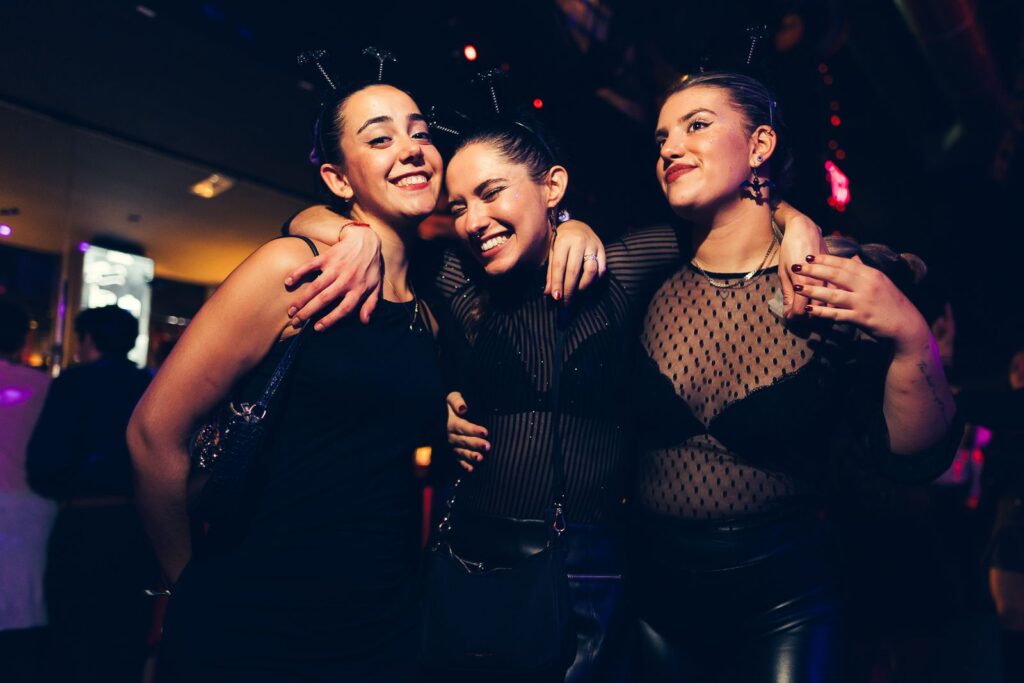 Three friends in black outfits with antenna headbands on Halloween in Florence