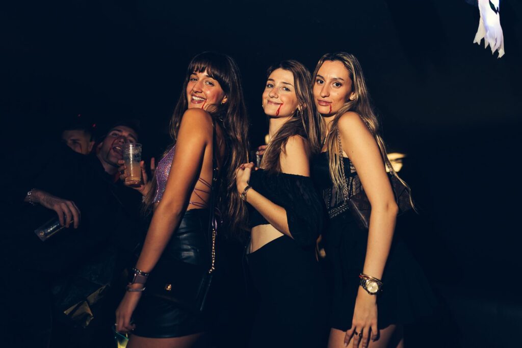 Tres amigas disfrazadas de vampiras con sangre falsa en una fiesta de Halloween en Florencia